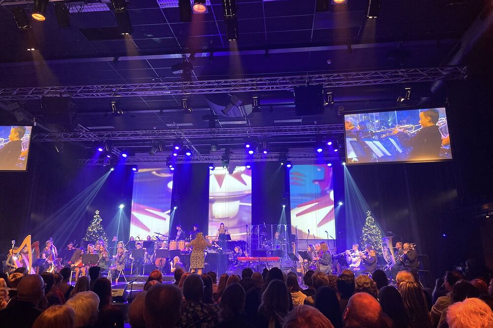 Publiek voor een verlicht podium tijdens een kerstconcert in Zoetermeer